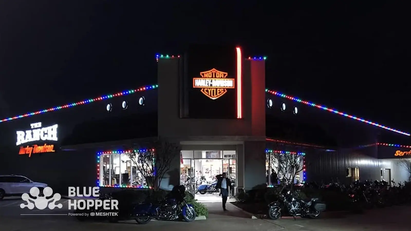 Permanent outdoor lighting brightening a bike dealership showroom lot, making vehicles visible after hours