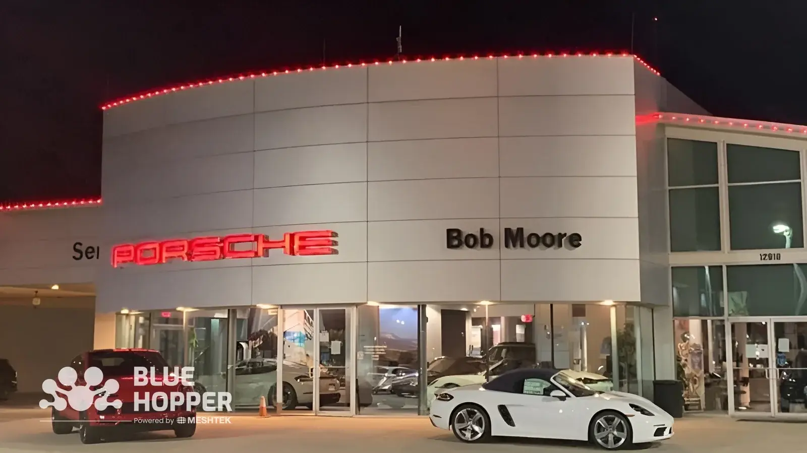 Permanent outdoor lighting brightening a car dealership showroom lot, making vehicles visible after hours