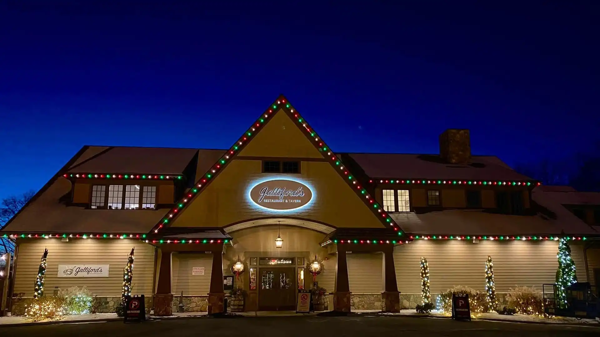 Permanent outdoor lighting accenting a restaurant roofline and storefront sign for strong street-level visibility